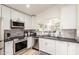 Modern kitchen with white cabinets, stainless steel appliances, and sleek countertops at 3269 E San Remo Ave, Gilbert, AZ 85234