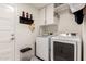 Well-organized laundry room with white washer and dryer, storage cabinets, and a patterned tile floor at 3269 E San Remo Ave, Gilbert, AZ 85234