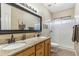 Bathroom with granite countertops, double sinks, and a glass-enclosed shower at 6409 N 11Th Dr, Phoenix, AZ 85013