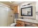 Bathroom featuring granite countertop, frosted shower, framed mirror, and vanity storage at 6409 N 11Th Dr, Phoenix, AZ 85013
