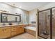 Bright bathroom featuring double sinks, soaking tub, and tiled walk-in shower at 6409 N 11Th Dr, Phoenix, AZ 85013