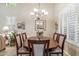 Cozy dining area with a round wooden table, seating for six, and a chandelier, creating a warm and inviting atmosphere at 6409 N 11Th Dr, Phoenix, AZ 85013
