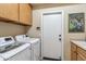 Laundry room with a modern washer and dryer and ample cabinet storage space above at 6409 N 11Th Dr, Phoenix, AZ 85013