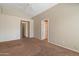 A large bedroom with neutral paint, tan carpet, and two open doors at 1024 N Ithica Ct, Chandler, AZ 85225