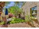 Secluded backyard with artificial turf, mature trees, a patio set, and a tranquil garden setting at 10591 E Saddlehorn Dr, Scottsdale, AZ 85258