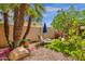 Landscaped backyard showcasing a tranquil seating area, palm trees, and artificial grass at 10591 E Saddlehorn Dr, Scottsdale, AZ 85258
