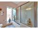 Bright bathroom featuring a glass-enclosed shower-tub, a window for natural light, and fresh towels at 10591 E Saddlehorn Dr, Scottsdale, AZ 85258