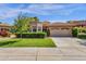 Charming home with tile roof, landscaped front yard, and attached two car garage on a sunny day at 10591 E Saddlehorn Dr, Scottsdale, AZ 85258
