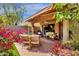 Charming covered patio featuring ample seating, tile flooring, and lush garden views at 10591 E Saddlehorn Dr, Scottsdale, AZ 85258