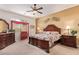 Comfortable main bedroom featuring a ceiling fan, a side table with lamp, and a cozy atmosphere at 10861 E Olla Ave, Mesa, AZ 85212