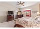 Well-lit main bedroom featuring a television, dresser, and ceiling fan, creating a relaxing and inviting atmosphere at 10861 E Olla Ave, Mesa, AZ 85212