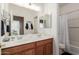 Bathroom with double vanity, wood cabinets, large mirror, and combination shower/tub at 1194 E Coyote Creek Way, San Tan Valley, AZ 85143