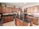 Kitchen featuring wood cabinetry, granite countertops, stainless steel appliances, and island at 1194 E Coyote Creek Way, San Tan Valley, AZ 85143