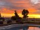 Backyard pool with a beautiful sunset reflecting off the surface of the water at 1194 E Coyote Creek Way, San Tan Valley, AZ 85143