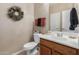 Stylish powder room features a decorative mirror, dark towels, and a wood vanity at 1194 E Coyote Creek Way, San Tan Valley, AZ 85143