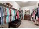 Spacious walk-in closet with ample hanging space, shelving, and a central ottoman at 1194 E Coyote Creek Way, San Tan Valley, AZ 85143