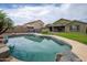 Backyard features a pool, desert landscaping, and a covered patio at 14091 W Bloomfield Rd, Surprise, AZ 85379