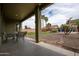 The backyard has a patio with dining set and the view extends to a grass and landscaped area at 14091 W Bloomfield Rd, Surprise, AZ 85379
