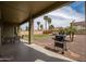 View of the patio and yard, featuring a barbecue, palms, and desert landscaping at 14091 W Bloomfield Rd, Surprise, AZ 85379