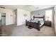 A cozy primary bedroom features a dark wood bed frame, carpeting, and a serene atmosphere at 14091 W Bloomfield Rd, Surprise, AZ 85379