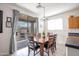 Open dining area with a modern light fixture and sliding glass door to the outside at 14091 W Bloomfield Rd, Surprise, AZ 85379