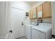 Functional laundry room with washer, dryer, and built-in cabinets at 14091 W Bloomfield Rd, Surprise, AZ 85379