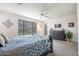 Well-lit main bedroom featuring neutral carpeting, a ceiling fan, and exterior access at 14091 W Bloomfield Rd, Surprise, AZ 85379
