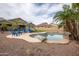 Backyard features a uniquely shaped pool, desert landscaping, and an adjacent patio area at 14091 W Bloomfield Rd, Surprise, AZ 85379