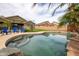 Sparkling pool features mature trees, lush desert landscaping, and an adjacent patio area at 14091 W Bloomfield Rd, Surprise, AZ 85379