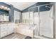 Bright bathroom featuring dual sinks, soaking tub with shutters, and glass enclosed shower at 16226 S 11Th Pl, Phoenix, AZ 85048