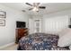 Bedroom with ceiling fan, floral bedding, and view to walk-in closet and ensuite at 16226 S 11Th Pl, Phoenix, AZ 85048