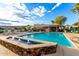 Community pool area with stone water feature with lounge chairs and shade structures at 16226 S 11Th Pl, Phoenix, AZ 85048