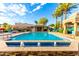 A clear blue pool with fountains sits among tall palm trees and patio seating in a beautiful outdoor setting at 16226 S 11Th Pl, Phoenix, AZ 85048