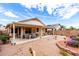 Large backyard featuring a covered patio with outdoor seating and a rock garden with decorative plants at 18031 W Udall Dr, Surprise, AZ 85374