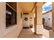 Inviting covered entrance with decorative door, sidelight, columns, and neutral stucco siding at 18031 W Udall Dr, Surprise, AZ 85374
