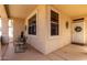 Covered front porch with seating area, attractive windows, and a welcoming entrance at 18031 W Udall Dr, Surprise, AZ 85374