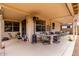 Covered patio features plenty of seating, a dining table, and an outdoor heater for comfortable enjoyment at 18031 W Udall Dr, Surprise, AZ 85374