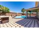 Backyard features a refreshing pool, spa, desert landscaping and a covered patio area, perfect for entertaining at 18640 W Pioneer St, Goodyear, AZ 85338