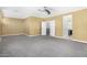 Large main bedroom with neutral carpet, white trim, fan and open ensuite bathroom and walk in closet at 18640 W Pioneer St, Goodyear, AZ 85338