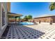 Inviting backyard pool area with covered patio and decorative brick pavers, great for outdoor entertaining at 18640 W Pioneer St, Goodyear, AZ 85338