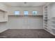 A large walk-in closet with shelving, clothing rods, neutral carpet and windows with natural light at 18640 W Pioneer St, Goodyear, AZ 85338