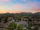 Aerial view of a residential community nestled amidst lush greenery with mountains in the background under a sunset sky at 20750 N 87Th St # 2038, Scottsdale, AZ 85255