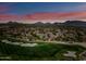 Aerial view of lush golf course, with residential community nestled in the mountains under a stunning sunset sky at 20750 N 87Th St # 2038, Scottsdale, AZ 85255