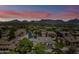 Aerial view of a residential community nestled amidst lush greenery with mountains in the background under a sunset sky at 20750 N 87Th St # 2038, Scottsdale, AZ 85255