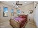 Bright bedroom featuring neutral walls, ceiling fan, and a wood-framed bed with patterned linens and natural light from sunny windows at 20750 N 87Th St # 2038, Scottsdale, AZ 85255