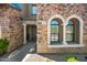 Close up of the home's entry featuring a stone facade, arched windows, and a well-lit walkway at 20750 N 87Th St # 2038, Scottsdale, AZ 85255