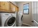 Bright laundry room with stacked washer/dryer, wood cabinets, and natural light from a window at 20750 N 87Th St # 2038, Scottsdale, AZ 85255