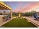 This backyard features an outdoor kitchen, a fountain, and artificial grass at 21127 W Minnezona Ave, Buckeye, AZ 85396