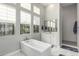 Bathroom featuring a soaking tub, dual sink vanity, tile floors, a shower, and large windows at 21127 W Minnezona Ave, Buckeye, AZ 85396