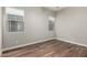 Empty bedroom featuring wood floors, neutral walls, and natural light from the window at 21127 W Minnezona Ave, Buckeye, AZ 85396